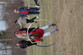 Students participating in indigenous games. Girl running through a moving hoop.